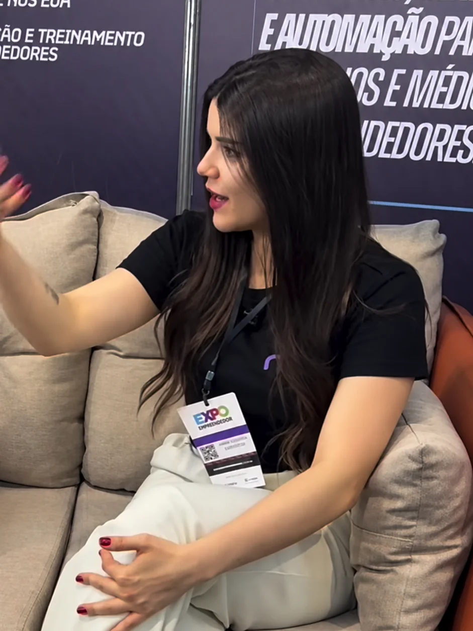 Anna Gouveia em entrevista num estande da Neway, diante do painel Assessoria de marketing, vendas e automação